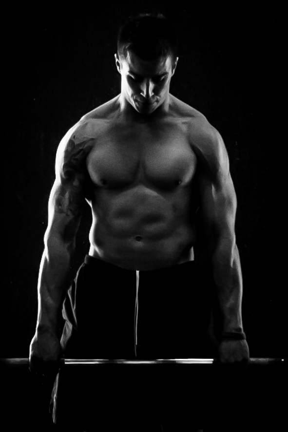 Muscular man with a barbell in a black and white gym setting