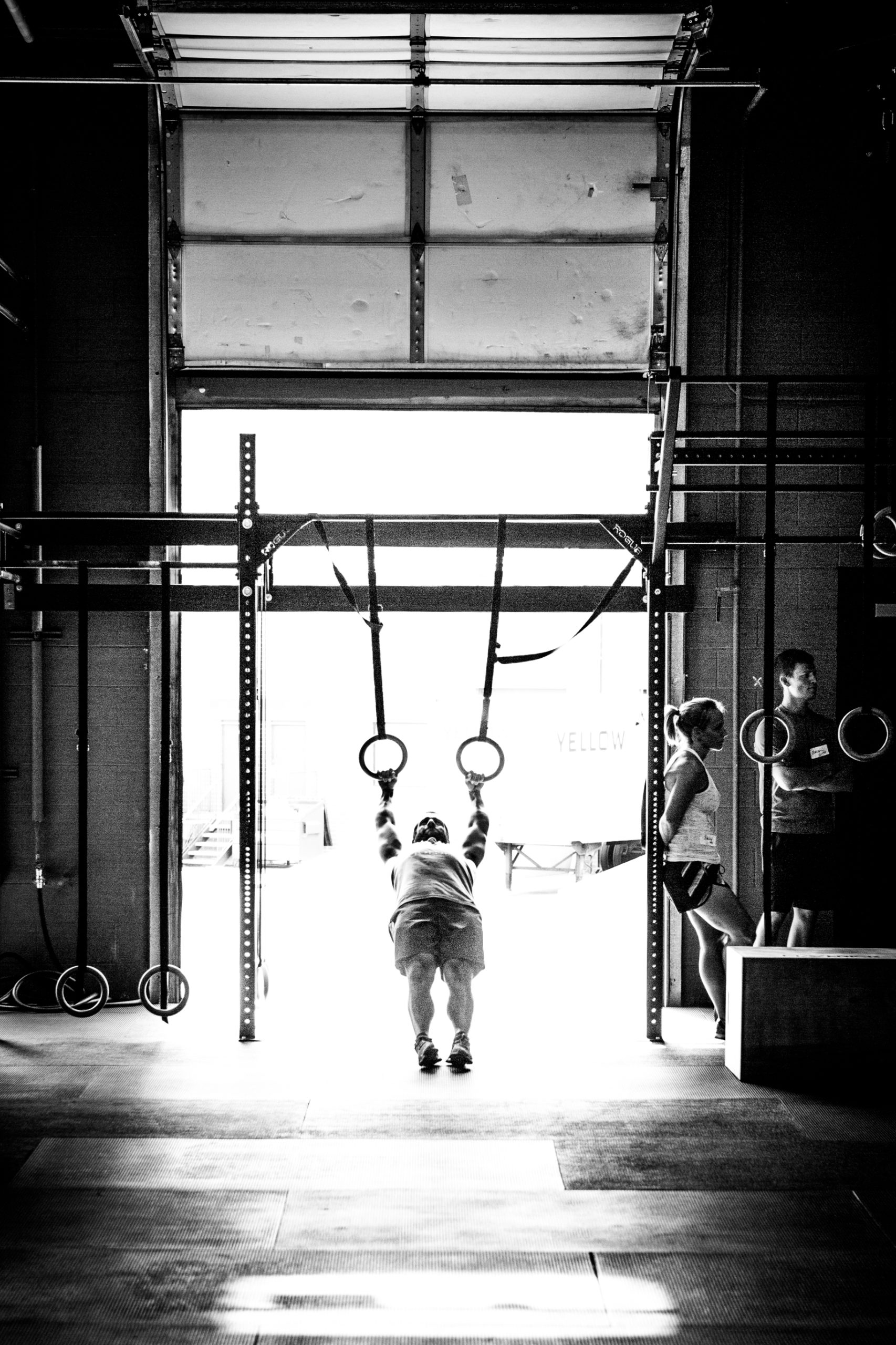 Young Athlete performing Gymnastic Ring accessory work in Black and White Gym Photo