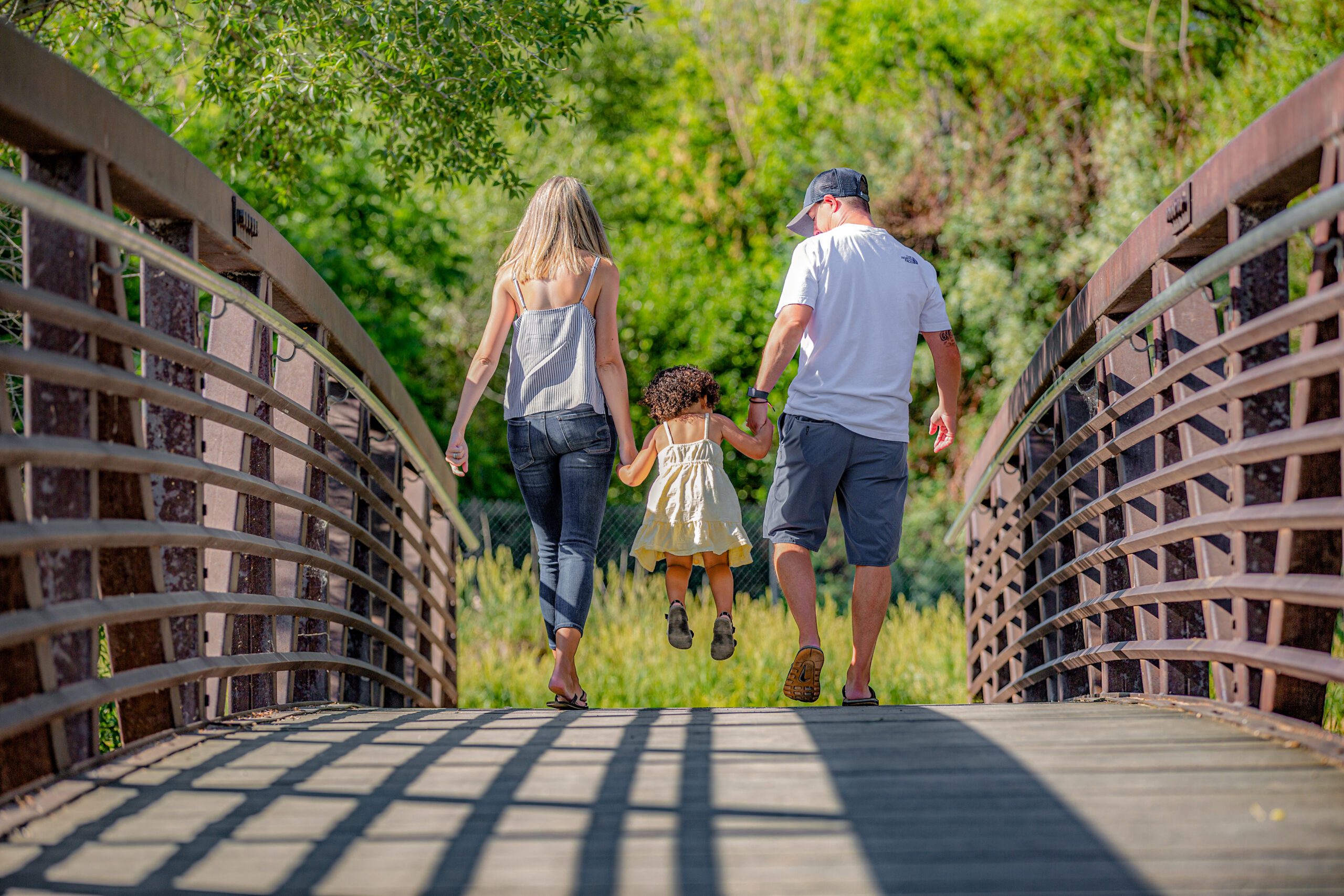 A family walking hand-in-hand across a bridge