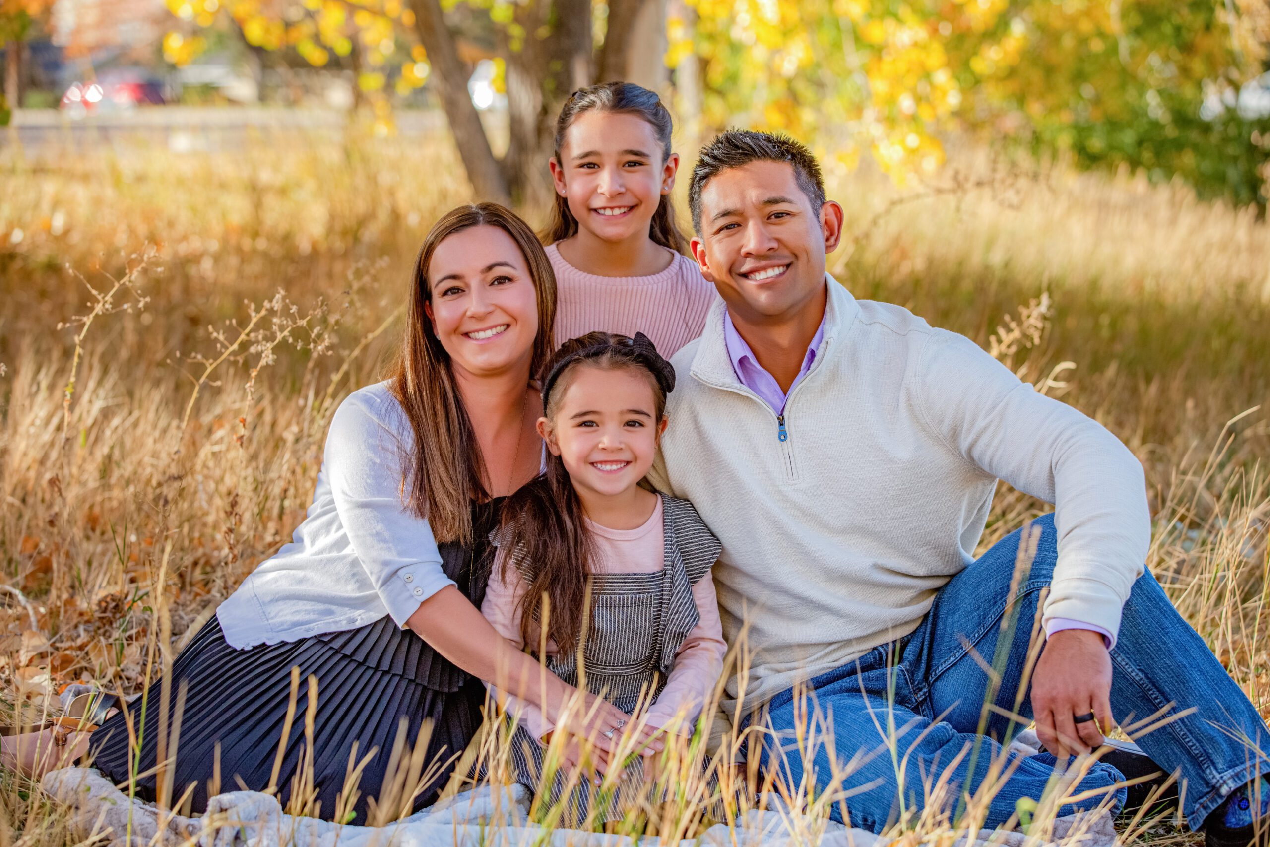 Family of four enjoying a sunny day outdoors.