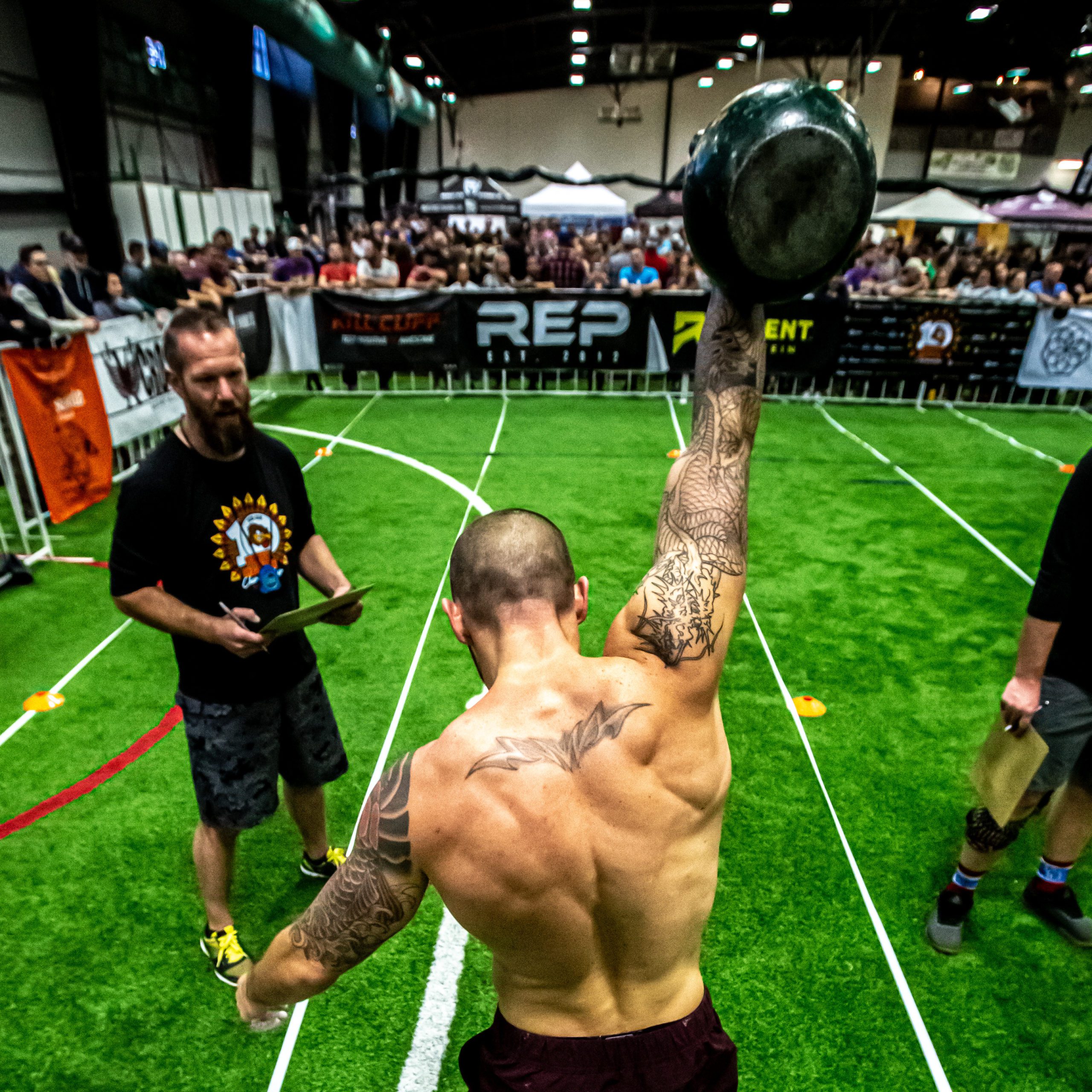 Competitive Kettlebell Lifting: Athlete in Action with Judge and Spectators