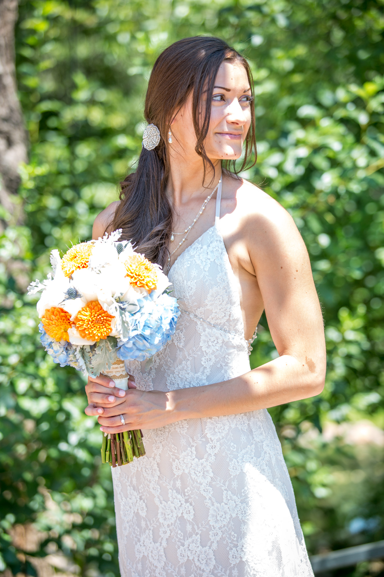 Serene Bride in Lace Halter Gown With Colorful Bouquet Against a Backdrop of Summer Greenery