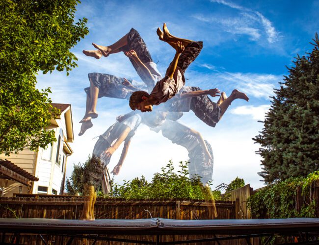 Person Performing an Acrobatic Flip on a Trampoline With Motion Blur Effects