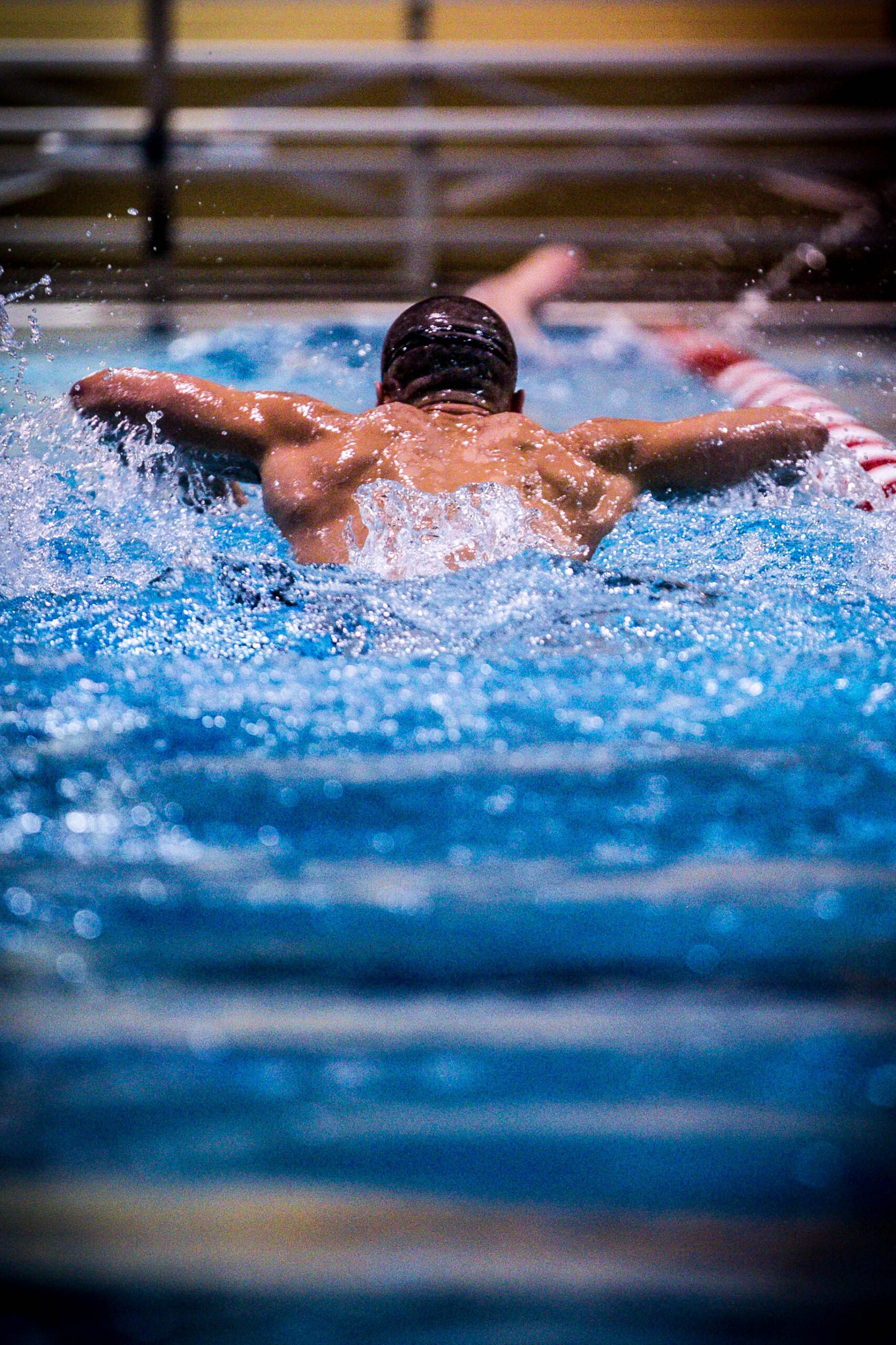 Competitive Swimmer in Mid-Butterfly Stroke with Dynamic Water Splash