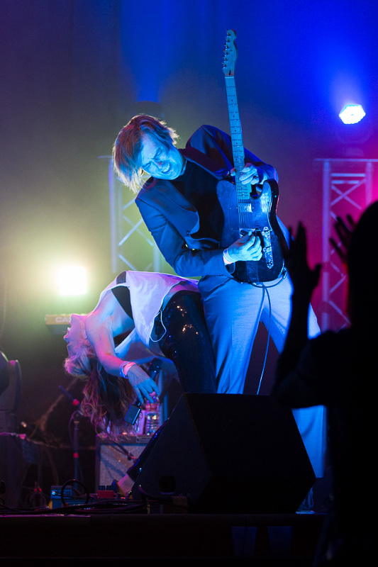 Female vocalist and male guitar player on stage give a live music performance.