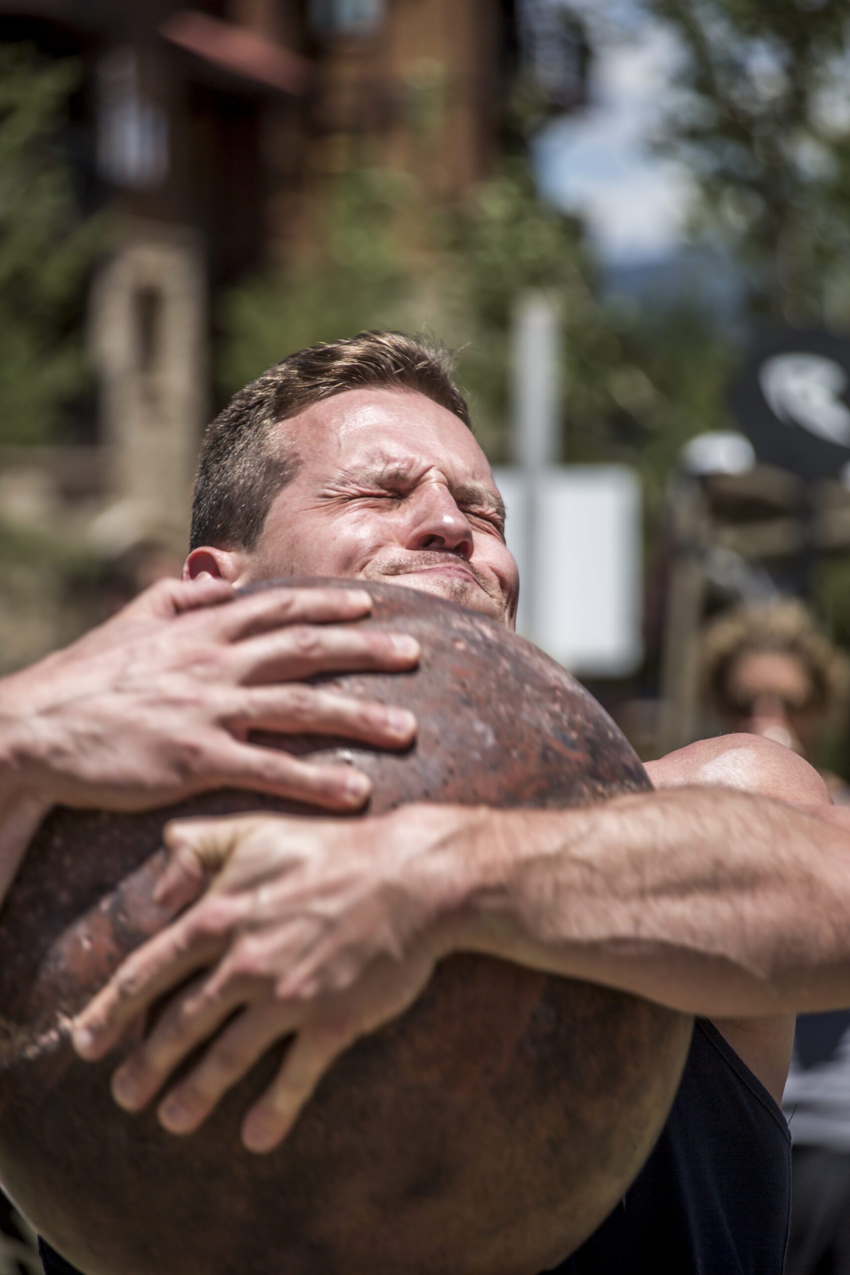 Male Athlete Lifting Atlas Stone with Intense Effort Close-Up