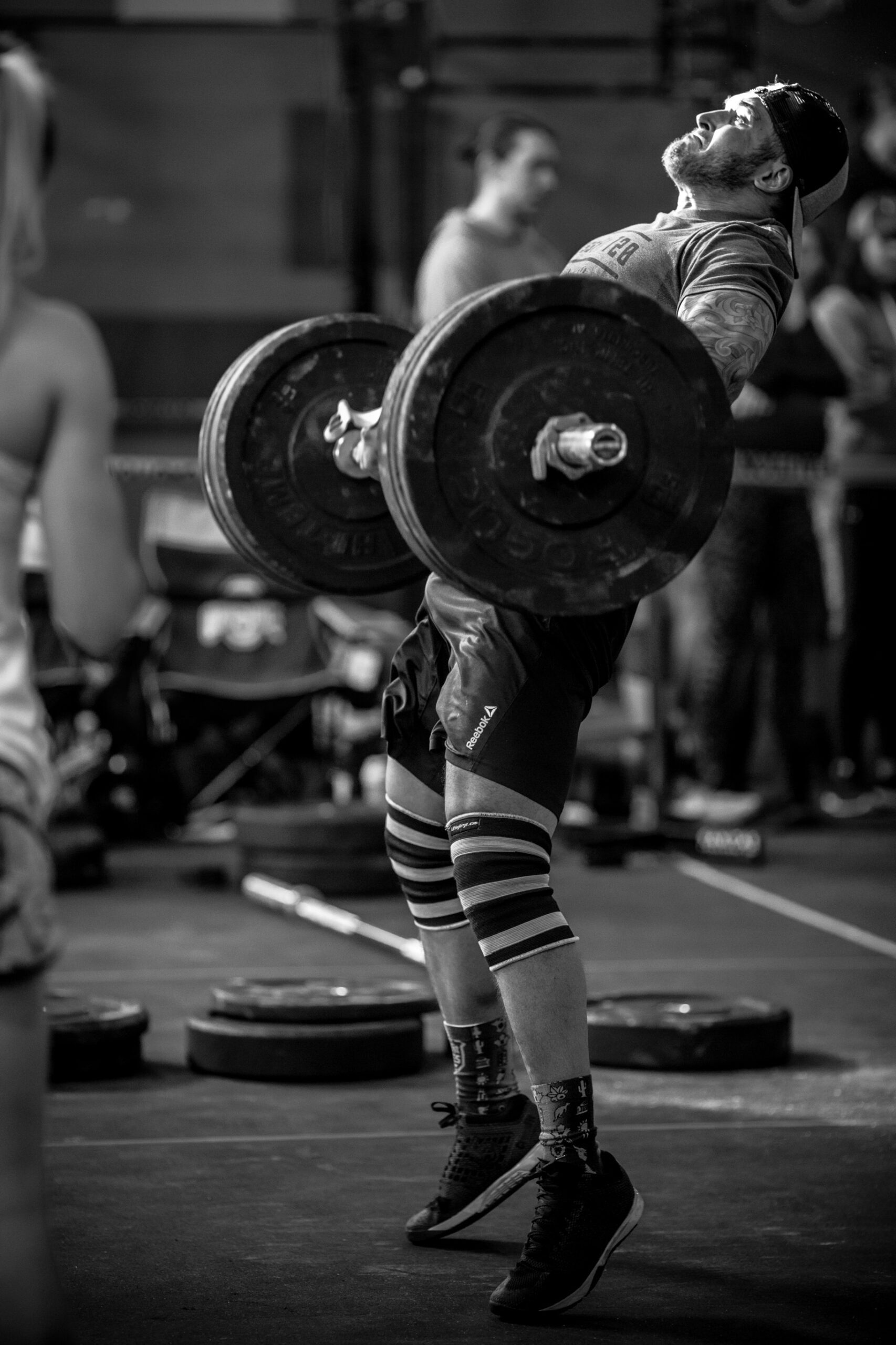 Male Athlete Performing Weighted Squat in Gym Black and White Photo