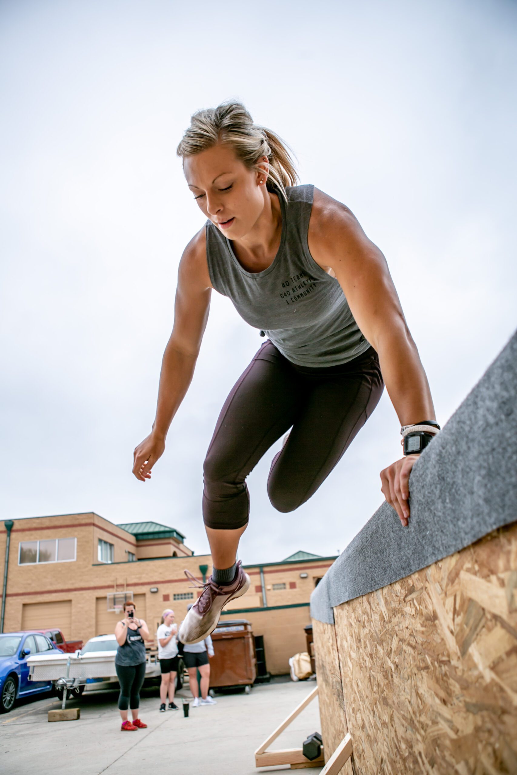 Focused Female Athlete Performing OCR Jump at Outdoor Fitness Event