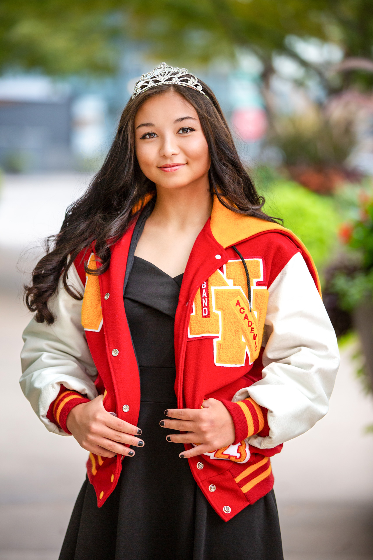 High school senior posing in a dress against an urban backdrop.