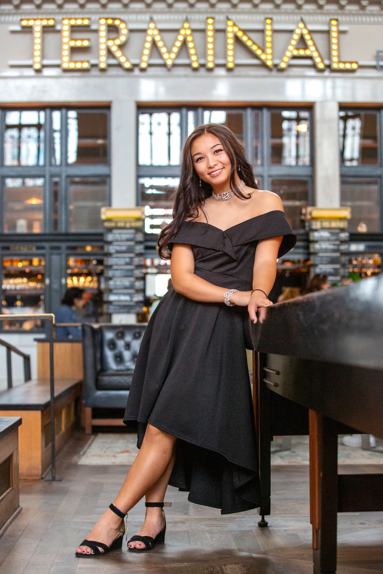 Senior high school female in a beautiful black dress relaxing in a unique environment.